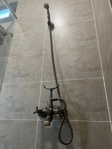 a shower head on a tiled floor in a bathroom at Tom Homestay Quy Nhơn in Quy Nhon