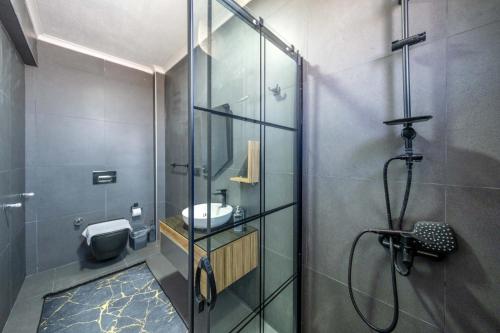 a bathroom with a glass shower and a sink at Villa Ada in Fethiye