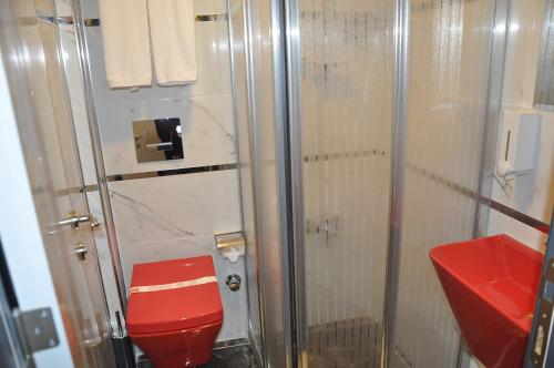 y baño con aseo rojo y ducha. en KOÇ OTEL ELİT TERMİNAL, en Isparta