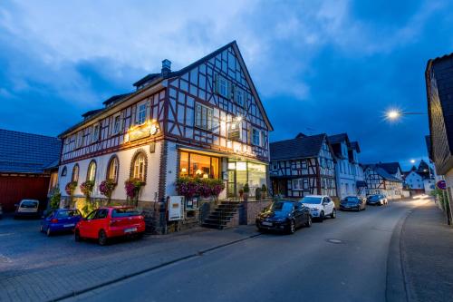 um edifício com carros estacionados ao lado de uma rua em Suite Appartements Da Giovanni em Gladenbach