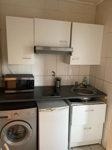 une cuisine avec un évier et une machine à laver dans l'établissement RENT APPART - Colombes, à Colombes