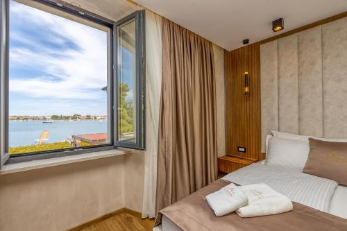 San Valentino Palace في أوماغ: غرفة نوم بسرير ونافذة كبيرة