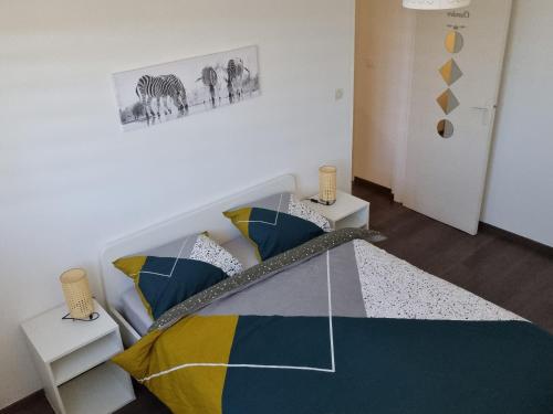 - une chambre avec un lit et des oreillers colorés dans l'établissement Bel appartement 2 chambres ,résidence privée, à Givet