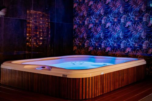 a jacuzzi tub in a room with a curtain at Jess Hotel & Spa Warsaw Old Town in Warsaw