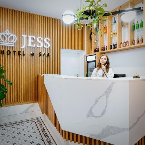 a woman sitting at a reception counter in a restaurant at Jess Hotel & Spa Warsaw Old Town in Warsaw