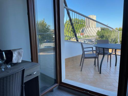 a room with a balcony with a table and a patio at Gli Angeli - Affittacamere in Monte SantʼAngelo