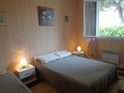 - une chambre avec deux lits, une fenêtre et deux lampes dans l'établissement appt T2 C Bougue, à Soustons