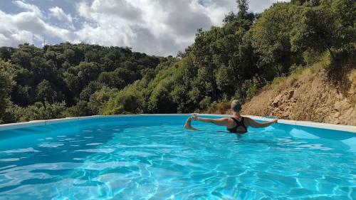 a woman in a swimsuit in a pool of water at Yogaville Sardegna in Luras