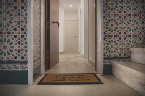 um corredor com um tapete de boas-vindas no chão em Acogedor apartamento en Triana em Sevilha