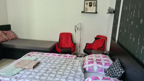 ケストヘイにあるZorka Apartmanのベッド1台と椅子2脚が備わる客室です。