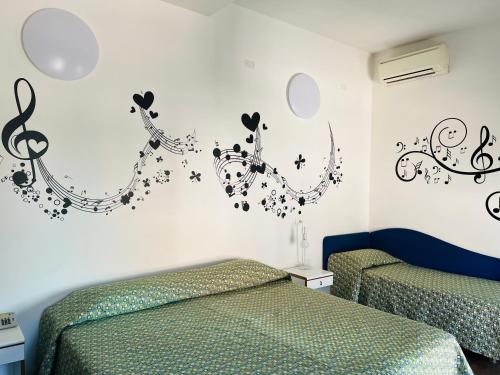 a bedroom with two beds with music notes on the wall at Albergo Visconti in Cremona