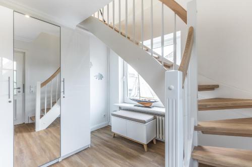 a staircase in a home with white walls and wooden floors at Appartement Friesenloft in Tinnum