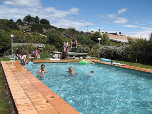 a group of people swimming in a swimming pool at 252 Beachside Motels & Holiday Park in Hokitika