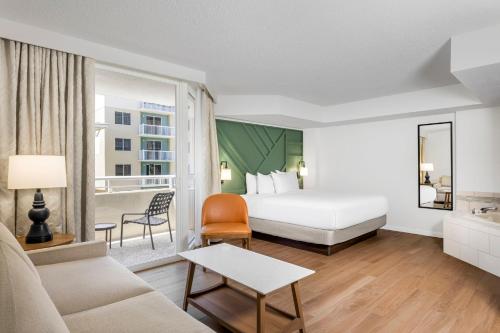 una habitación de hotel con una cama y un sofá en Club Wyndham Santa Barbara, en Pompano Beach
