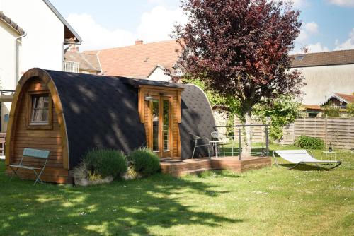 a small house with a black roof in a yard at Champagne Philippe Martin in CumiÃ¨res