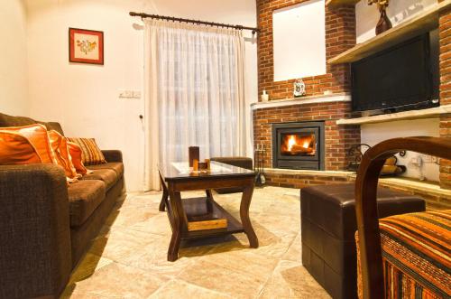 a living room with a couch and a fireplace at Archontiko I Misirlou in Kalopanayiotis
