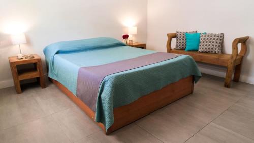a bedroom with a large bed and a bench at Pousada Tartaruga in Búzios