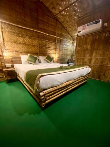 a large bed in a room with a green floor at Tridhara HomeStay in Guwahati