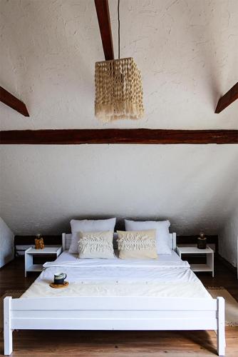 a white bed in a room with a chandelier at Siedlisko Liskowate - Bieszczady in Ustrzyki Dolne