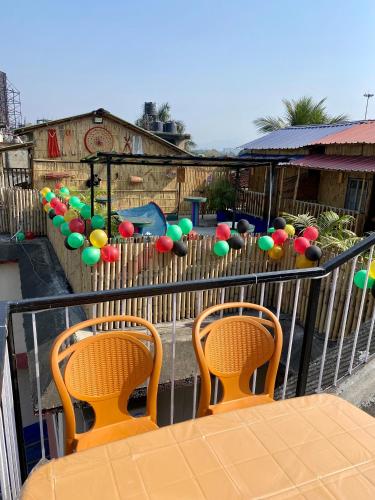 a balcony with two chairs and a fence with balloons at Tridhara HomeStay in Guwahati