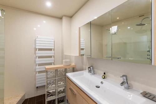 ein Bad mit einem Waschbecken und einem Spiegel in der Unterkunft Superbe 3 pièces avec piscine et tennis in Cannes