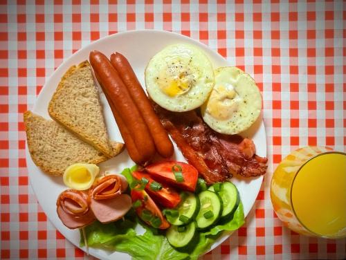 a plate of breakfast food with eggs bacon and toast at M&W Hotel Wronowski in Łomża