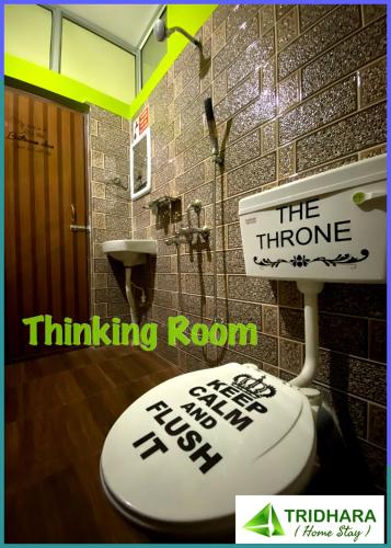 a bathroom with a toilet with a sign on it at Tridhara HomeStay in Guwahati