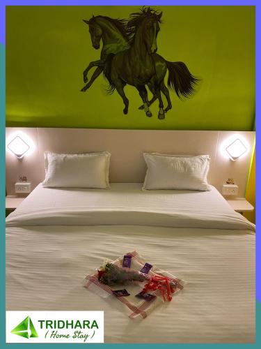 a bedroom with a bed with two horses on the wall at Tridhara HomeStay in Guwahati