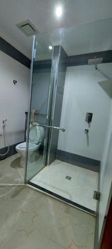 a bathroom with a glass shower and a toilet at EMAN HOUSE in Salalah