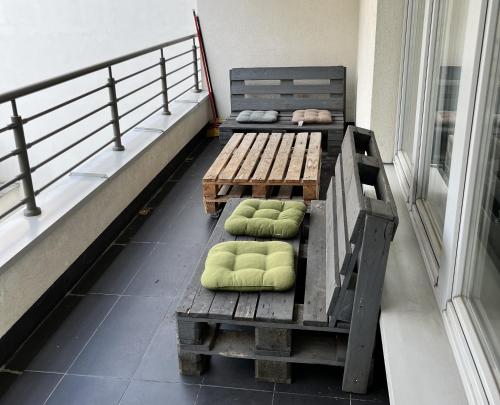 ワルシャワにあるLabo Apartment Dzialdowskaの- バルコニー(緑の枕付きのベンチ2台付)
