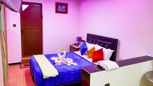 a bedroom with a bed with two stuffed animals on it at Hotel EL MARSA LA PLAYA in Laayoune