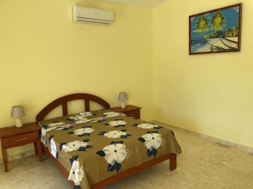 a bedroom with a bed with a bedspread with cows on it at Punta Rucia Cristal Beach in Punta Rucia