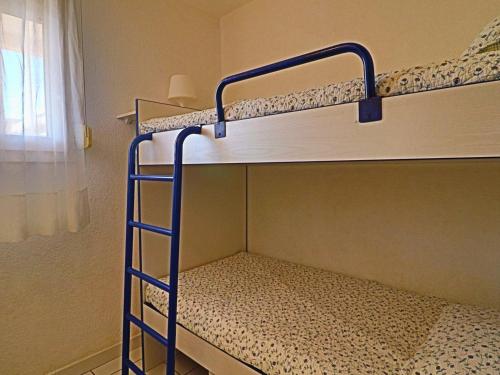 deux lits superposés dans une chambre avec fenêtre dans l'établissement Appartement 2 pièces cabine pour 6 pers avec terrasse et parking - FR-1-472A-174, à Sète