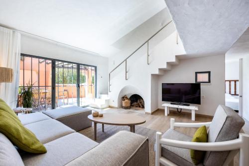 a living room with a couch and a tv at Onyria Quinta da Marinha Villas in Cascais