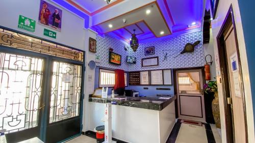a bar in a restaurant with purple lighting at Hotel EL MARSA LA PLAYA in Laayoune