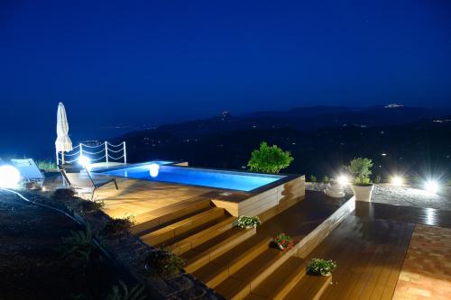 a night view of a swimming pool with stairs and lights at Villa Magliolo in Cefalù