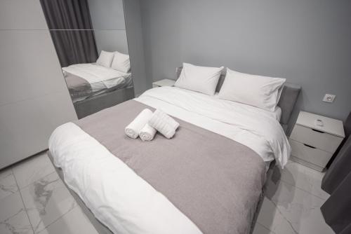 ein Schlafzimmer mit einem Bett mit zwei Handtüchern darauf in der Unterkunft Sea & City LUXURY SUITE in Thessaloniki