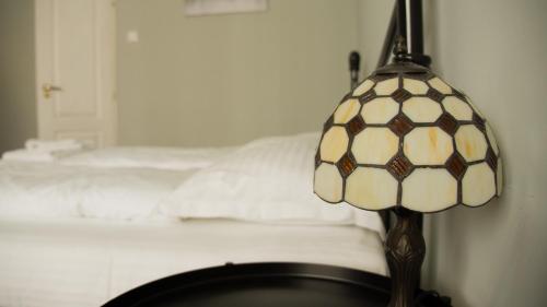 a lamp sitting on a table next to a bed at Allegro apartments city center in Oradea