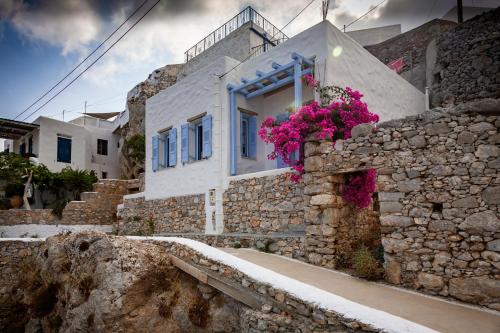 una casa con flores a un lado. en Villa Nina, dreamy little cycladic home in Amorgos, en Órmos Aiyialís