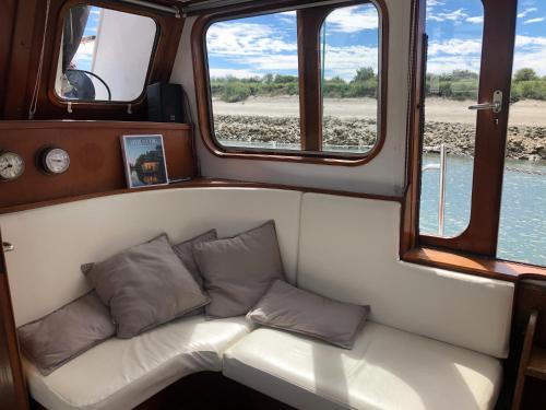a couch in the back of a boat with windows at La Vedette Hollandaise in Étaples