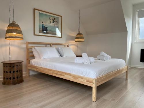 a bedroom with a large bed with white sheets and pillows at Pass the Keys The Sands Superb Newly Refurbished Beach Home in Rye