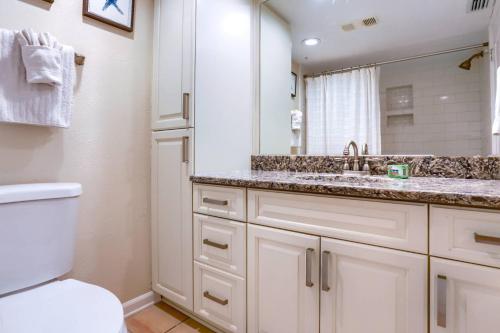 La salle de bains est pourvue d'un lavabo, de toilettes et d'un miroir. dans l'établissement 2 Pipers Nest, à Clearwater Beach