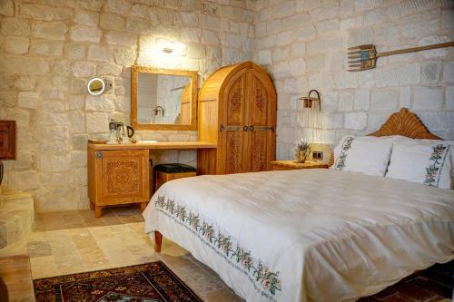 a bedroom with a bed and a vanity and a mirror at Aşk-ı Nare Cave Hotel Swimming Pool Hot & SPA in Nevşehir