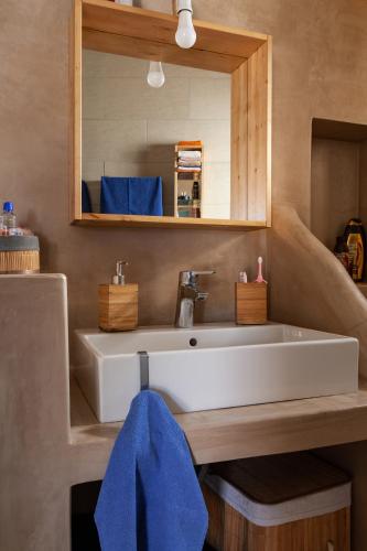 a bathroom with a white sink and a mirror at Villa Nina, dreamy little cycladic home in Amorgos in Órmos Aiyialís