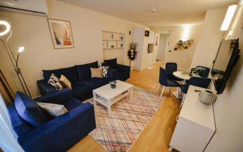 a living room with a blue couch and a table at Come a Lot Aparthotel Batumi in Batumi