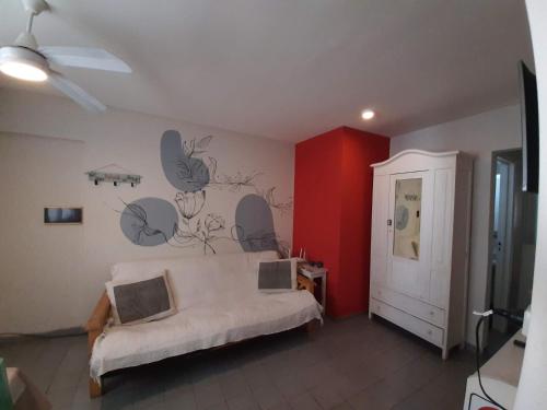1 dormitorio con cama y pared roja en Excelente departamento Barrio Sur en San Miguel de Tucumán