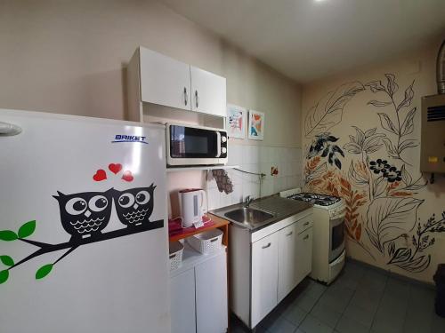 a kitchen with a refrigerator with two owls on it at Excelente departamento Barrio Sur in San Miguel de Tucumán