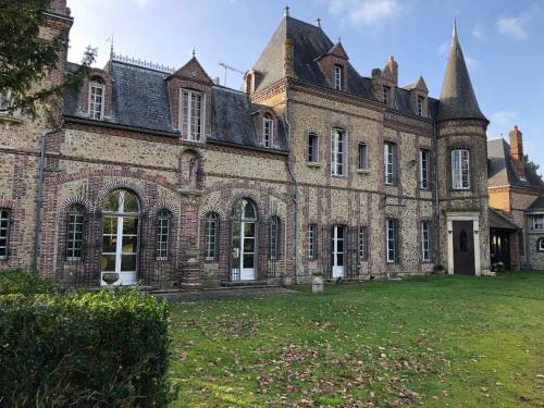 an old brick building with a grass yard at Château De Swann in Illiers