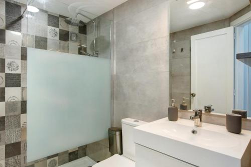 Un baño con lavabo, inodoro y espejo. en Casa Princesa, en Playa del Cura