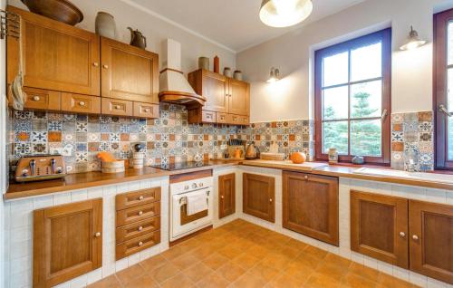 a large kitchen with wooden cabinets and a window at Pet Friendly Home In Wygon With Kitchen in Wygon